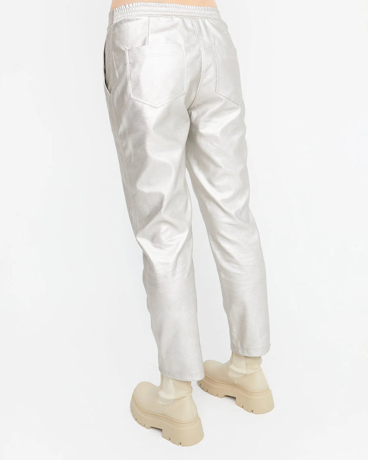 The futuristic back view of a woman wearing Ozai N Ku Metallic Pants, Gloss, exuding a fashion-forward vibe.