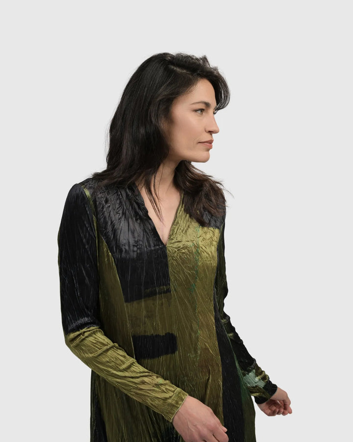 A woman wearing the ALEMBIKA Al Fresco Cocoon Dress in Olive and black.