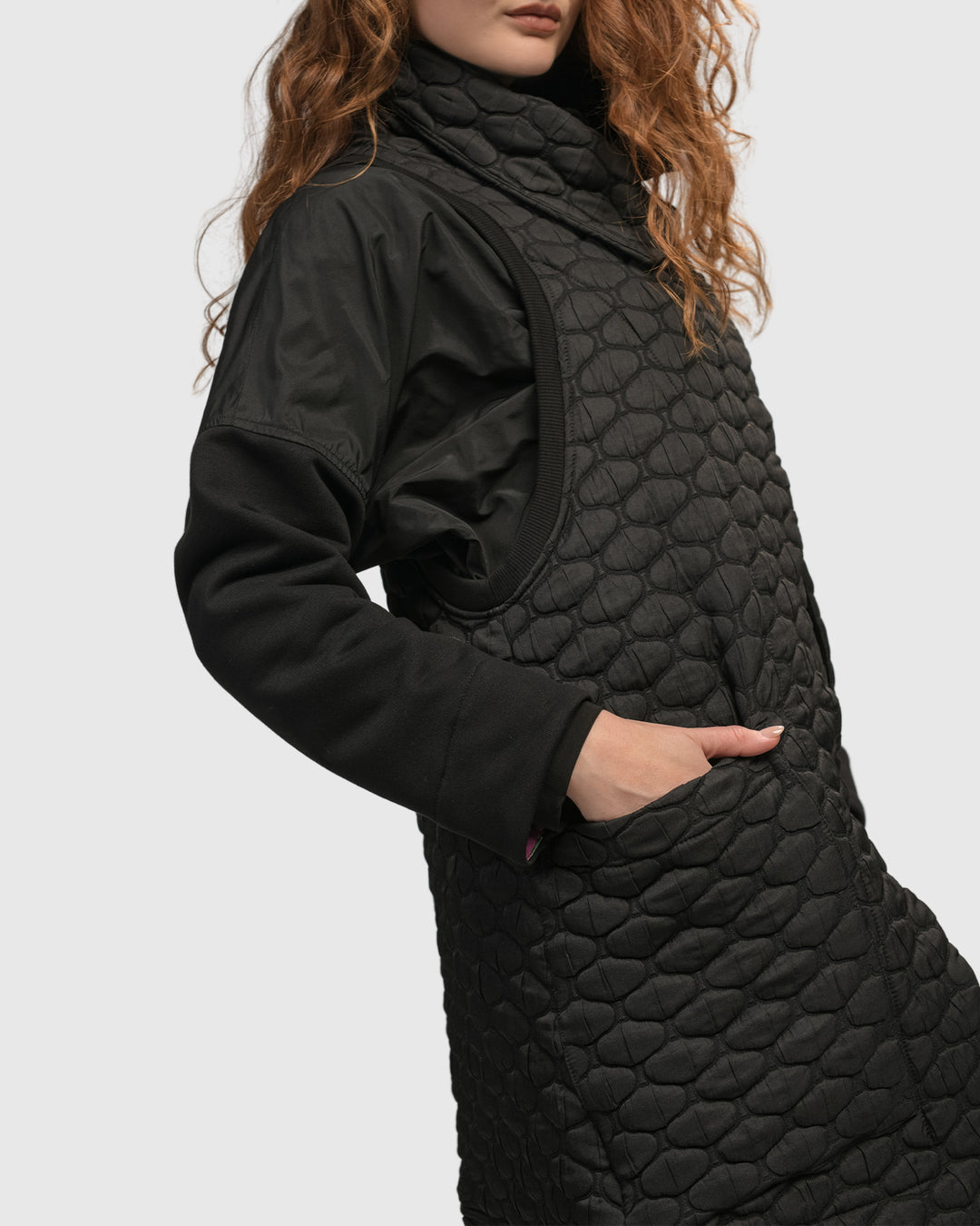 A woman donning a trendy ALEMBIKA black quilted jacket exudes a hip urban vibe with the Urban Soft Punk Vest.