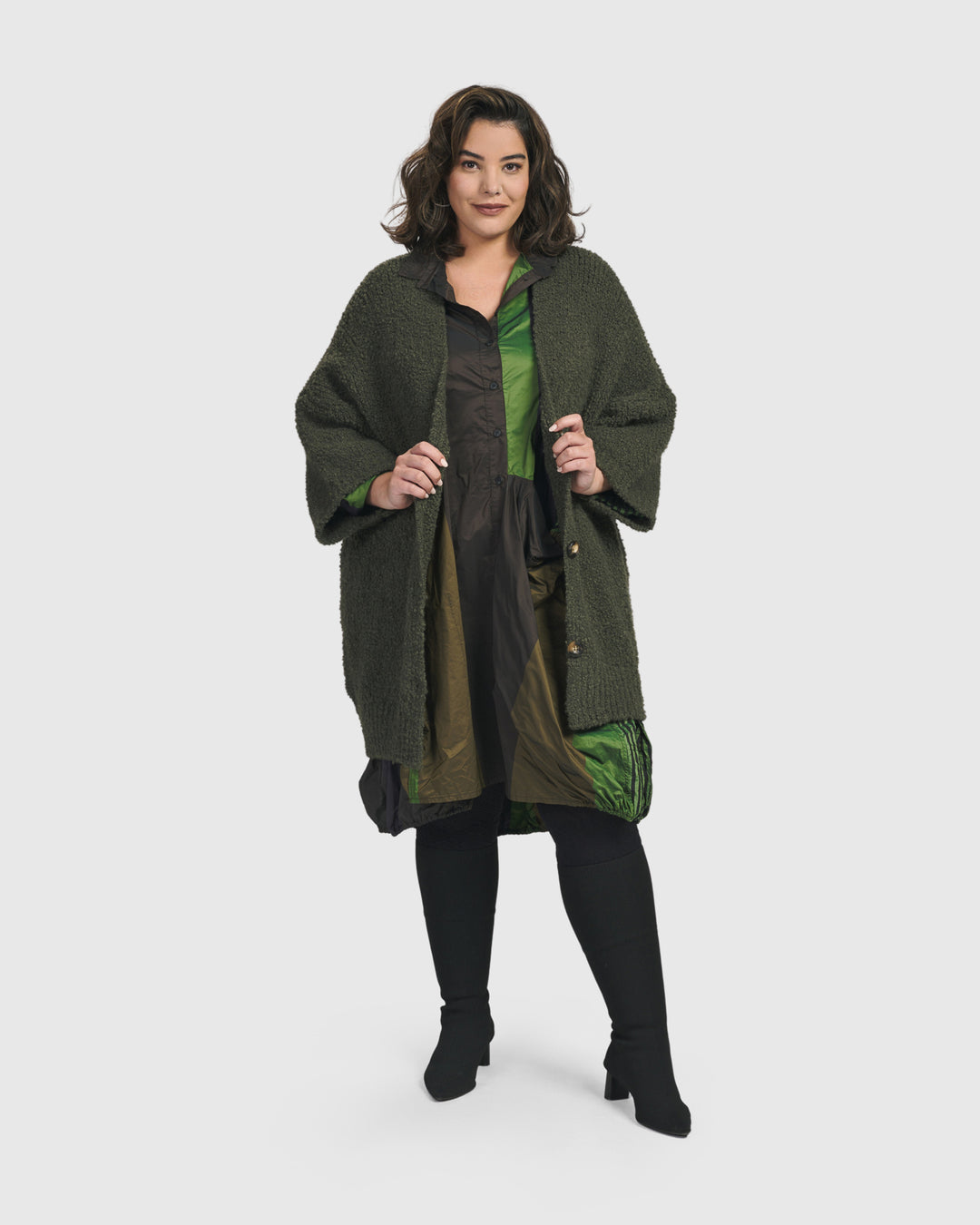 A plus size woman wearing a cozy green Sunday Cardigan from ALEMBIKA.