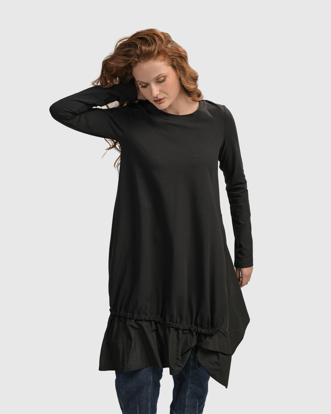 A woman wearing an ALEMBIKA Urban New Wave Tunic Top in Black with long sleeves.