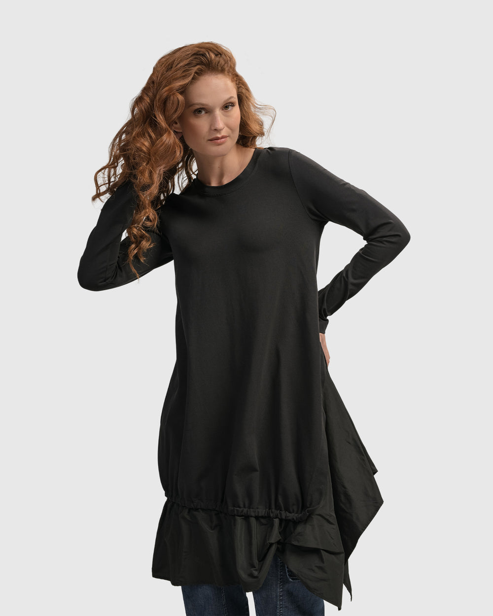 A woman wearing an ALEMBIKA Urban New Wave Tunic Top, Black with long sleeves and nylon skirting.